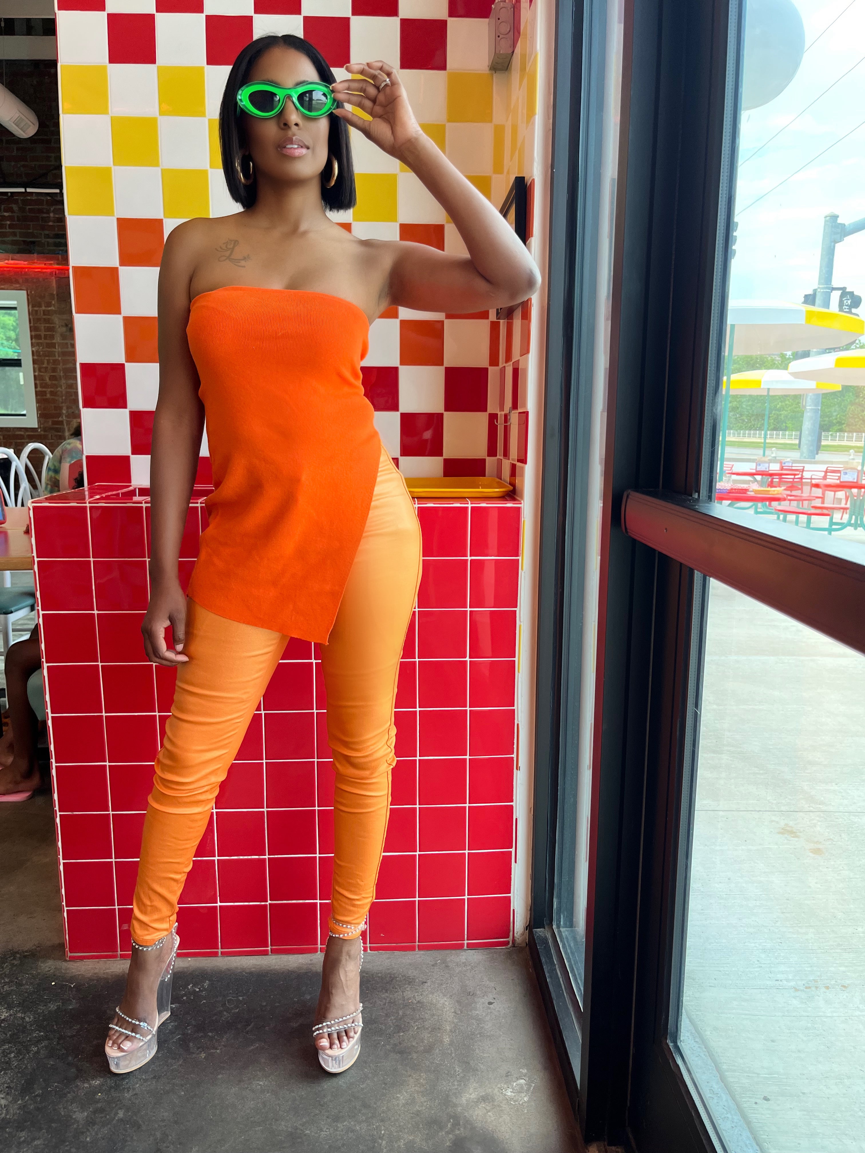 Model wearing orange metallic pants